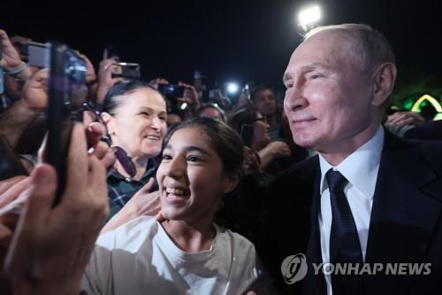 지난달 28일 다게스탄에서 시민들 환영을 받으며 함께 사진 찍는 푸틴 대통령 [AP 연합뉴스 자료사진]