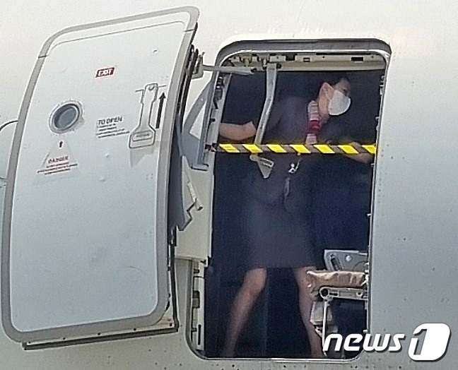 지난 26일 제주에서 출발해 대구로 향하던 아시아나항공기에 탑승한 30대 남성 A씨가 대구공항 상공에서 비상문을 강제로 개방해 승객들을 공포에 떨게 한 가운데 승무원이 비상문을 온몸으로 막고 있는 사진이 확보됐다. (독자 제공) 2023.5.28/뉴스1 ⓒ News1 공정식 기자