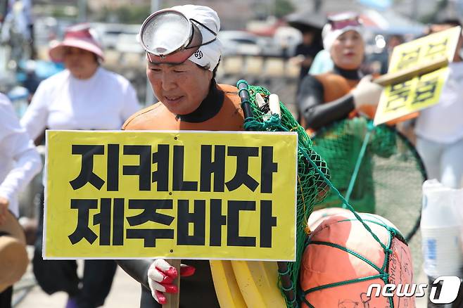 제주 함덕어촌계 해녀회원이 6일 오전 '함덕 앞바다에서 진행 예정인 '일본 후쿠시마 원전 오염수 해양방류 반대 해상시위'에 앞서 어선에 오르고 있다. 2023.7.6/뉴스1 ⓒ News1 강승남 기자