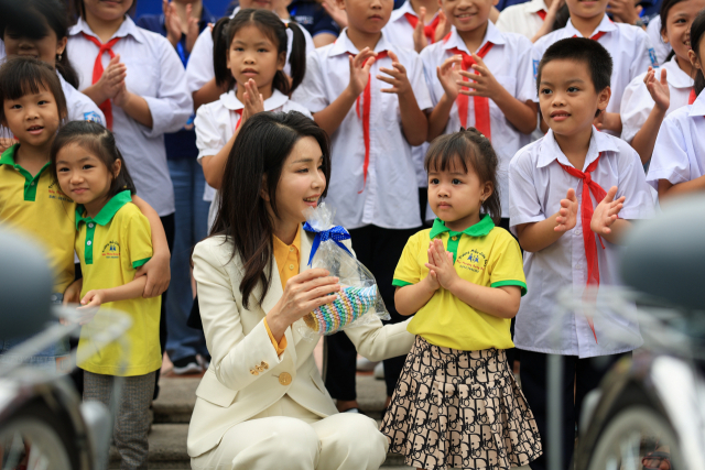 ▲윤석열 대통령과 베트남을 국빈 방문 중인 김건희 여사가 22일(현지시간) '하노이 SOS 어린이마을 학교'에서 열린 '바이크 런(Bike Run)' 자전거 기부 행사에서 기념촬영 전 한 아이가 주는 선물을 받고 있다. '바이크 런'은 통학거리가 멀어 어려움을 겪는 베트남 어린이들에게 자전거를 선물하는 프로그램으로, 2015년부터 지금까지 1천여 대의 자전거가 기부됐다. ⓒ연합뉴스