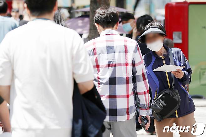 23일 서울 중구 명동거리에서 한 어르신이 식당 홍보 전단지를 나눠주고 있다. 2023.5.23/뉴스1 ⓒ News1 민경석 기자