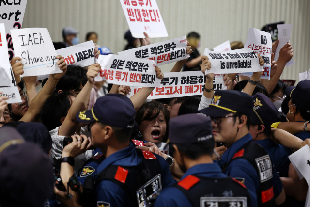 라파엘 그로시 국제원자력기구(IAEA) 사무총장의 입국이 예정된 7일 밤 김포공항 국제선 입국장 인근에서 시민단체가 그로시 사무총장의 방한을 반대하는 손 피켓을 들고 있다. 연합뉴스