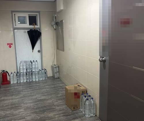 비상구와 연결된 서울의 한 빌라 복도 끝 비상구 앞에 배달 온 생수가 쌓여있다. 화재가 발생하면 대피로가 차단될 위험이 있다. [촬영 조서연]