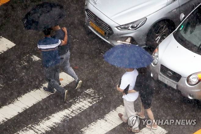 지난달 29일 광주 서구 치평동에서 소나기에 시민들이 함께 우산을 쓰고 걷고 있다. [연합뉴스 자료사진]