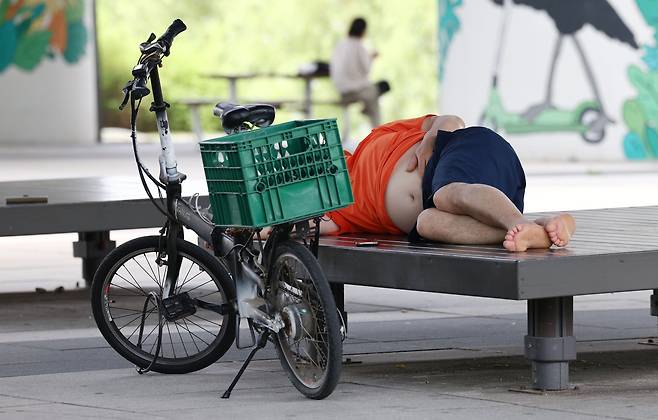 장맛비가 그치고 다시 무더위가 시작된 지난 5일 오후 서울 영등포구 마포대교 아래 그늘에서 한 시민이 평상에 누워 낮잠을 자고 있다. 사진은 기사와 직접적 관련 없음. /연합뉴스