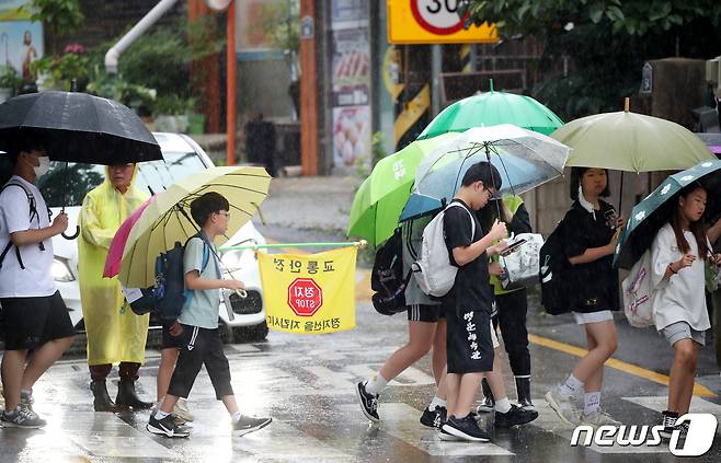 비가 내리는 4일 오전 광주 광산구 한 초등학교 앞에서 아이들이 우산을 쓰고 등교하고 있다.2023.7.4/뉴스1 ⓒ News1 김태성 기자