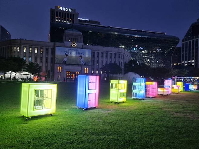 한여름 밤 서울광장 풀밭 위에서 독서를 즐길 수 있는 ‘밤의 여행 도서관’의 LED 빛 서가. 서울도서관 제공 