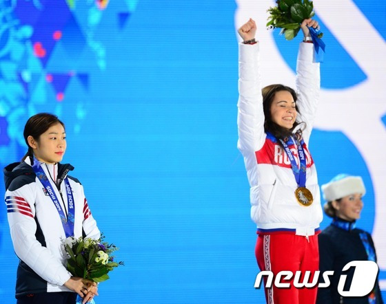 '피겨여왕' 김연아가 22일(한국 시간) 러시아 소치 해안클러스터의 올림픽 파크 내 메달 프라자에서 열린 피겨 여자 싱글 시상식에서 은메달을 목에 걸고 미소짓고 있다. 1위 아델리나 소트니코바(러시아),2위 김연아(대한민국),3위 카롤리나 코스트너(이탈리아)2014.2.22/뉴스1