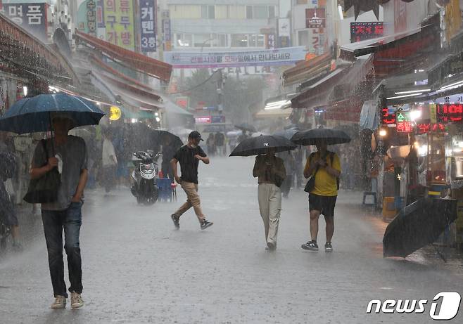 수도권 지역에 호우특보가 내려진 11일 서울 남대문시장에 시민들이 우산을 쓰고 발걸음을 옮기고 있다. 2023.7.11/뉴스1 ⓒ News1 신웅수 기자