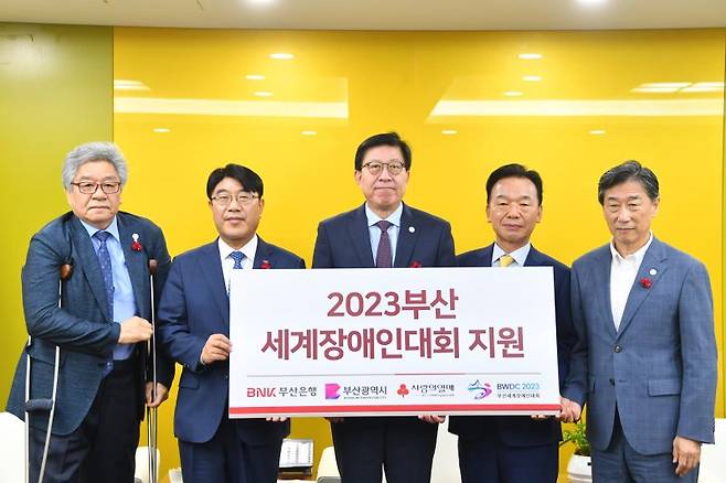 조창용 2023 부산세계장애인대회 부대회장, 방성빈 BNK부산은행장, 박형준 부산시장, 최금식 부산사회복지공동모금회장, 오준 2023 부산세계장애인대회 조직위원회 공동위원장(왼쪽부터)이 11일 오전 시청에서 후원금 전달식을 갖고 기념촬영을 하고 있다. 부산시 제공