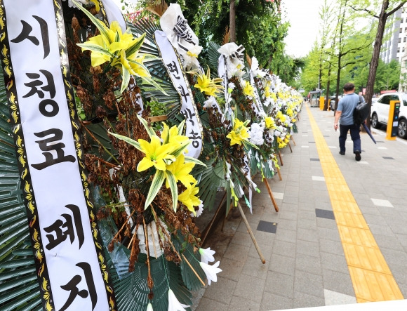 KBS 수신료를 분리 징수하도록 한 방송법 시행령 일부 개정안이 국무회의와 대통령 재가를 거쳐 현실화한 11일 서울 여의도 KBS 주변에 보수단체가 세워 놓은 근조화환들이 늘어서 있다. 연합뉴스