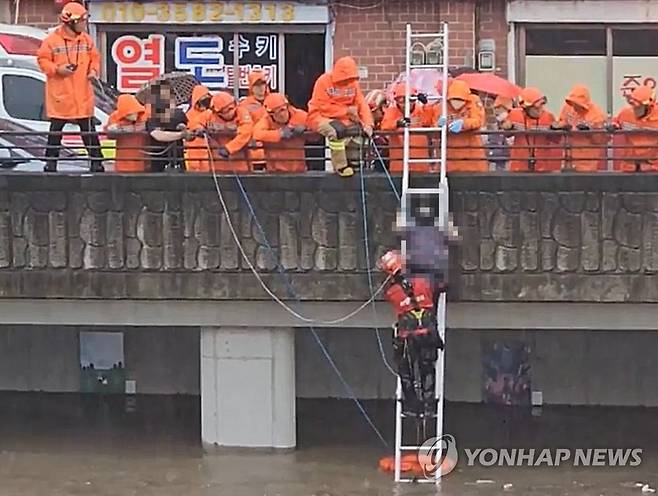 갑자기 불어난 하천에 고립된 시민 구조 (부산=연합뉴스) 집중호우가 쏟아진 11일 오후 부산 사상구 학장천 물이 불어나면서 고립된 시민이 119에 의해 구조되고 있다. 2023.7.11 [부산소방본부 제공. 재판매 및 DB금지] ready@yna.co.kr