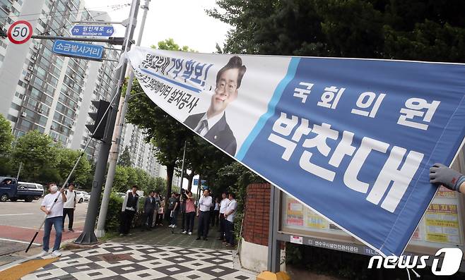 인천 연수구 관계자가 12일 연수구 동춘동 거리에 걸린 정당현수막을 철거하고 있다. 인천시는 지난 8일 정당현수막을 규제하는 내용의 '옥외광고물 조례개정안'을 시행하고 11일까지 계도·홍보기간을 거쳐 12일부터 본격적인 단속을 시작했다. 2023.7.12/뉴스1 ⓒ News1 정진욱 기자