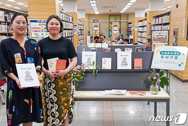 김해문화재단 소속 곽다솜 과장(왼쪽)과 안소정 과장이 각각 출간한 책을 도서관에 기증했다. (김해문화재단 제공)