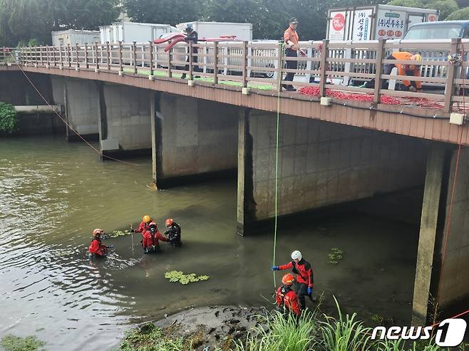 12일 오후 소방대원들이 부산 사상구 학장천에서 집중호우로 실종된 60대 여성을 찾기 위해 로프 수색 작업을 벌이고 있다. 실종자 A씨는 전날 오후 3시25분께 학장천에서 집중호우에 불어난 물에 휩쓸려 실종됐다.(부산소방재난본부 제공) ⓒ News1 노경민 기자