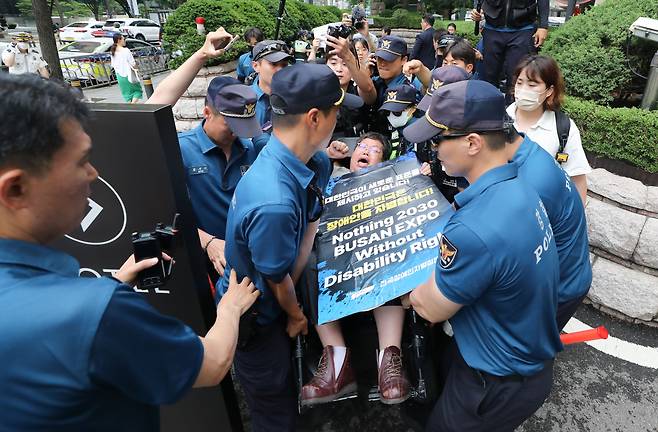 서울 중구 롯데호텔 지하주차장 출구에서 시위를 벌인 전국장애인차별철폐연대(전장연) 회원이 휠체어를 탄 채로 들려 옮겨지고 있다. 전장연은 이날 한덕수 총리와의 면담을 요청하며 롯데호텔 앞에서 시위를 벌였다. 한 총리는 같은 장소에서 정보보호의 날 기념식에 참석했다. /뉴스1