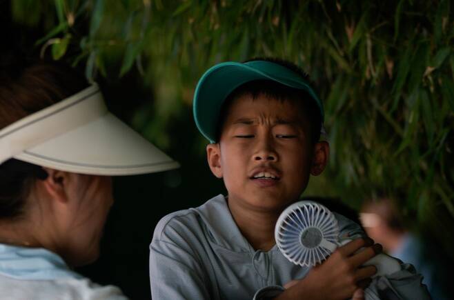 낮 기온이 35도가 넘었던 어느 날 베이징의 한 동물원에서 어린이가 선풍기를 얼굴에 들이대고 있다. AP 뉴시스