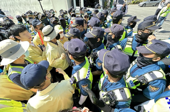 6월17일 대구 중구 반월당역 인근에서 퀴어문화축제 측 무대차량 진입을 위해 교통 정리에 나선 경찰관들과 이를 막으려는 대구시 공무원들이 대치하고 있다. ⓒ연합뉴스