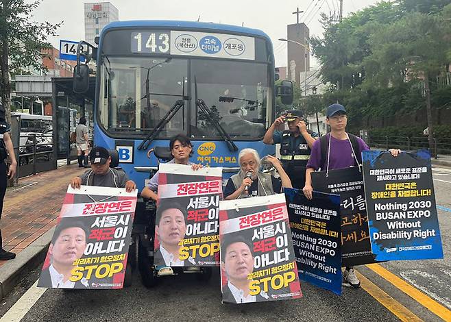 전장연이 13일 오전 서울 종로구 혜화동로터리 중앙버스전용차로에서 시내버스를 막고 있다. (사진=연합뉴스)