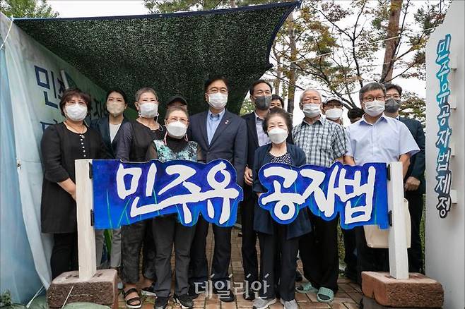 지난해 7월 더불어민주당 우상호 의원(당시 비상대책위원장)과 우원식 의원이 서울 여의도 국회 정문 앞에서 ‘민주유공자법 제정’을 촉구하며 9개월째 농성중인 전국민족민주유가족협의회(유가협)와 민주유공자법제정추진단의 천막농성장을 방문해 유족들과 기념촬영을 하고 있다. (공동취재사진) ⓒ데일리안 홍금표 기자