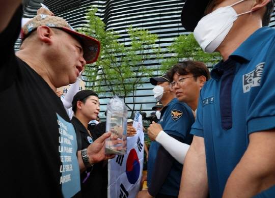 촛불연대 회원들이 지난 8일 오후 서울 종로구 일본대사관 앞에서 직접 후쿠시마 원전 인근 해상에서 떠온 바닷물을 일본대사관 측에 전달하려다 경찰에 가로막히고 있다. <연합뉴스>