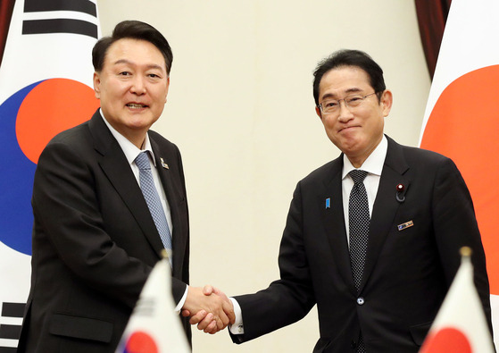 President Yoon Suk Yeol, left, and Japanese Prime Minister Fumio Kishida shake hands during a bilateral meeting on the sidelines of the NATO summit in Vilnius, Lithuania, Wednesday. [JOINT PRESS CORPS]