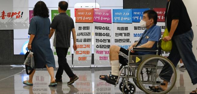 혼란한 의료현장 민주노총 전국보건의료산업노동조합(보건의료노조)이 지난 2004년 이후 19년 만에 총파업에 돌입한 13일 오전 서울 성북구 고려대안암병원에서 휠체어를 탄 환자가 ‘가자 7.13 산별 총파업!’ 등의 문구가 담긴 선전용 팻말들 앞을 지나가고 있다.  문호남 기자