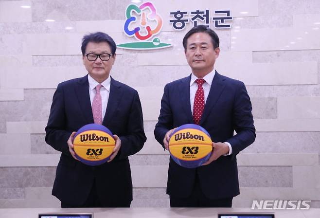 [서울=뉴시스]최희암(왼쪽) 전 연세대 농구부 감독이 13일 국제농구연맹(FIBA) 3대3 홍천 챌린저 대회 조직위원장에 선임됐다. 신영재 홍천군수와 최희암 조직위원장이 농구공을 들고 포즈를 취하고 있다. (사진 = 한국3x3농구연맹 제공)