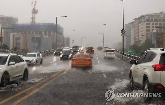 퍼부은 비에 물 차오른 도로 (서울=연합뉴스) 황광모 기자 = 서울 지역에 폭우로 인해 호우주의보가 내려진 13일 오후 서울 용산구 한남오거리 인근 한남 고가 남단이 집중적으로 내린 비로 인해 침수돼 차량이 서행 운전하고 있다. 2023.7.13 hkmpooh@yna.co.kr