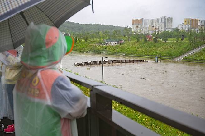 시민들이 14일 폭우로 물이 불어난 반곡동 삼성천을 걱정스럼 표정으로 바라보고 있다. / 뉴스1　