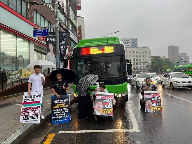 전국장애인차별철폐연대(전장연)이 14일 아침 8시께 서울 동작구 대방역 인근 버스정류장에서 버스 운행을 막아서는 기습 시위를 진행하고 있다. 전장연 제공