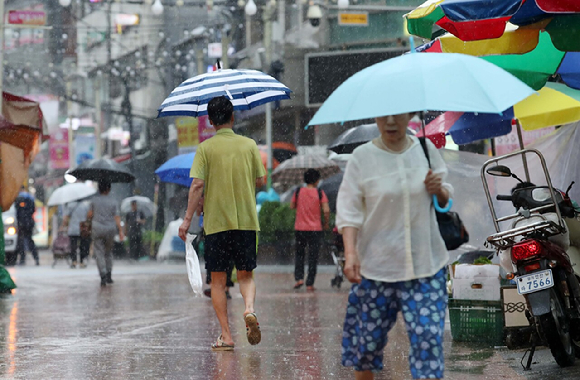 장맛비가 내리는 지난 13일 오후 서울 동작구 성대전통시장에서 시민들이 우산을 쓰고 오가고 있다. [사진=뉴시스]