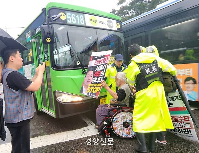 14일 서울 여의도 국회의사당역 앞 버스정류장에서 경찰이 박경석 전국장애인차별철폐연대(전장연) 상임공동대표를 인도쪽으로 이동시키고 있다. 김세훈 기자