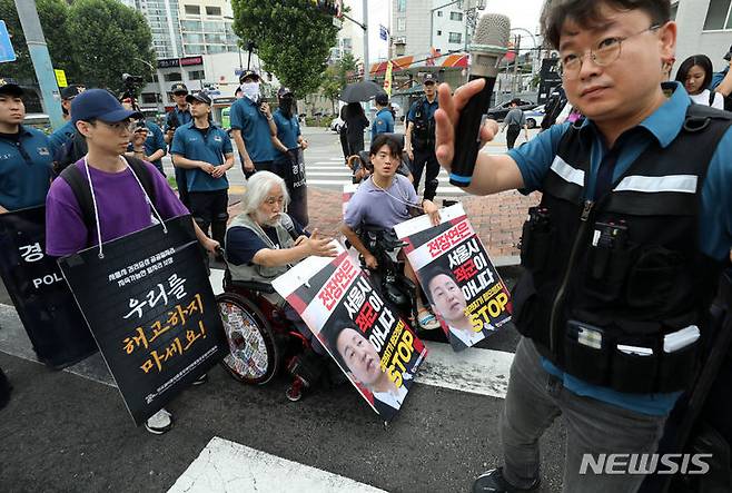 [서울=뉴시스] 김명년 기자 = 박경석 전국장애인차별철폐연대 대표와 회원들이 13일 오전 서울 종로구 혜화동로터리에서 '오세훈 서울시장 전장연 죽이기 마녀사냥 중단 촉구 비폭력 불복종 버스행동'을 하고 있다. 2023.07.13. kmn@newsis.com