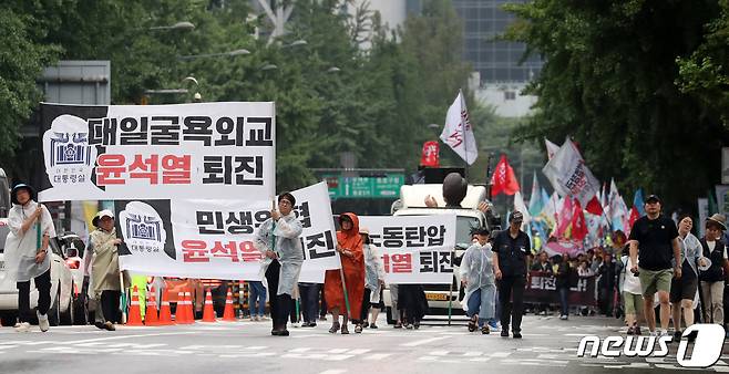 15일 서울 종로구 사직로 일대에서 열린 '윤석열 정권 퇴진 7.15 범국민대회'에서 참가자들이 후쿠시마 핵오염수 해양투기 반대, 윤석열 정권 퇴진 등을 촉구하며 일본대사관 방향으로 행진하고 있다. 2023.7.15/뉴스1