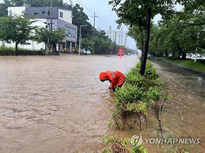 호우로 침수된 도로 (군산=연합뉴스) 전북 14개 시·군 전역에 호우 특보가 내려진 14일 오전 군산시 사정동의 한 도로가 침수돼 소방대원들이 배수 작업 중이다. 2023.7.14 [전북소방본부 제공. 재판매 및 DB 금지] warm@yna.co.kr ※ 기사와 직접 관계가 없는 자료사진입니다.