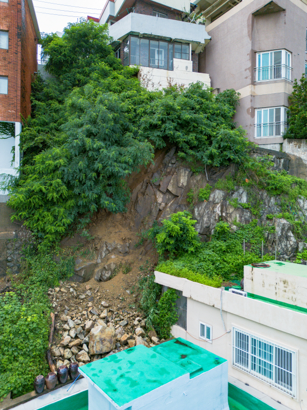 지난 12일 동구 초량동 한 주택 뒤쪽 지반이 어제 내린 호우로 무너져 있다. / 김영훈 기자hoonkeem@