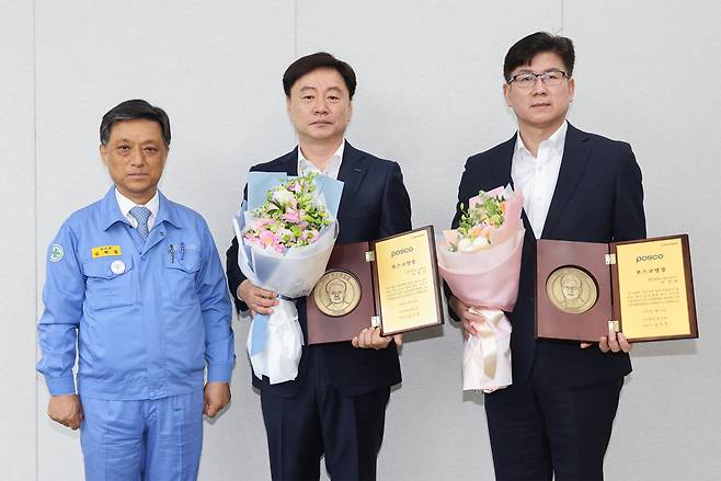 김학동(왼쪽부터) 포스코 부회장이 13일 포항 제강부 이영진 과장과 광양 제강설비부 이선동 과장에게 2023 포스코명장 임명패를 수여하고 기념 촬영하고 있다. [포스코 제공]