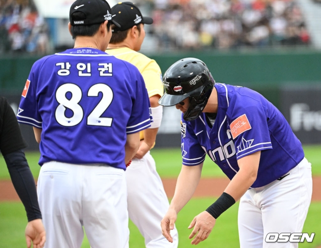 나눔 올스타 박건우(오른쪽)가 15일 부산 사직야구장에서 열린 2023 KBO 올스타전에서 1회말 안타를 치고 나간 뒤 강인권(NC) 1루 코치에게 90도 고개를 숙이며 장비를 전달하고 있다.