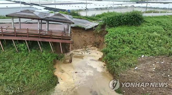 폭우로 무너져 내리는 논산 금강 제방 (논산=연합뉴스) 사흘째 이어지는 기록적인 폭우로 16일 오전 충남 논산시 성동면 우곤리 인근 금강 제방이 유실됐다. 사진은 금강과 우곤리 마을 사이에 놓인 제방이 무너져 내리는 모습. 2023.7.16 [논산시 제공. 재판매 및 DB 금지] swan@yna.co.kr