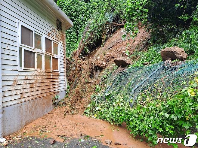 17일 오전 8시42분쯤 전남 광양시 중마동 한 초등학교 뒷산에서 토사가 유실돼 씨름부 체육관으로 흙더미가 쏟아져 위태로운 모습을 보이고 있다. (광양시 제공) 2023.7.17/뉴스1