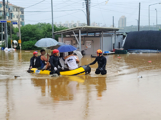 15일 많은 비로 침수 피해가 발생한 충남 공주시 옥룡동 다세대 주택 단지에서 119 대원들이 보트를 이용해 구조작업을 벌이고 있다. [독자 제공. 공주=연합뉴스]