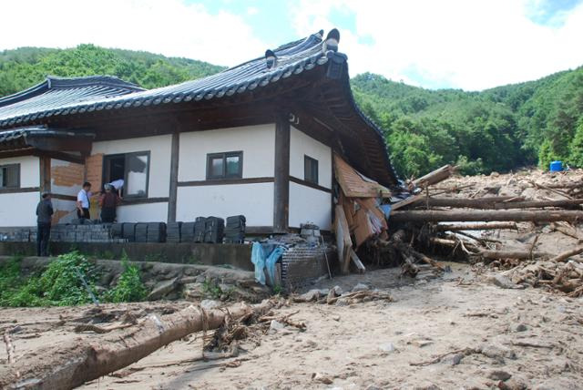 17일 경북 봉화군 춘양면 학산리에서 산사태로 매몰돼 숨진 하모 부부의 집에 하씨 유족들이 유품을 꺼내기 위해 창문을 통해 들어가고 있다. 이용호 기자