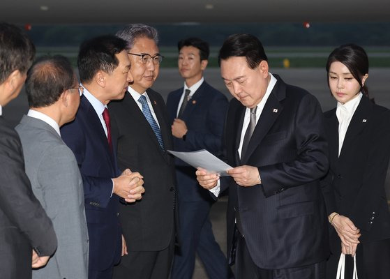 리투아니아에서 열린 북대서양조약기구(NATO·나토) 정상회의 참석과 폴란드·우크라이나 방문을 마친 윤석열 대통령이 17일 성남 서울공항을 통해 귀국, 국민의힘 김기현 대표가 준비한 수해 관련 자료를 살펴보며 대화하고 있다. 연합뉴스