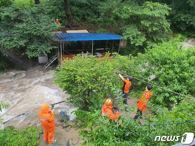 18일 오후 1시 52분쯤 밀양시 청도면 조천리에서 도랑에 물이 불어나 하천변 농막에 고립된 60·70대 여성 2명을 출동한 소방대원들이 구조하고 있다.(경남소방본부)