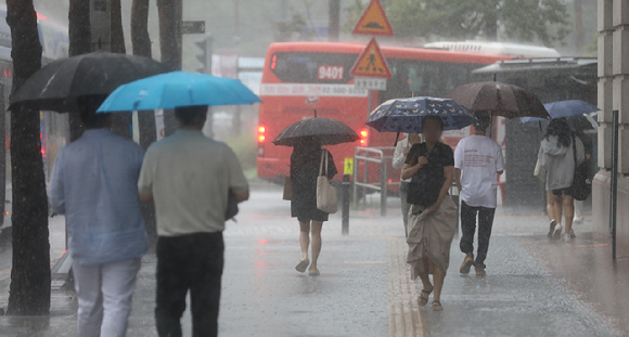 장마가 이어진 오후 서울 중구 을지로1가 사거리 인근에서 우산을 쓴 시민들이 발걸음을 재촉하고 있다. [사진=뉴시스]