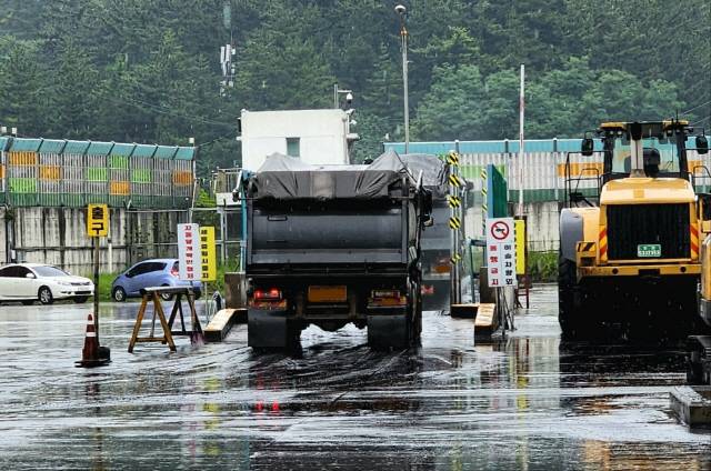 ▲ 동해·삼척 주민·시민단체들이 반발하는 가운데 삼척블루파워가 18일부터 동해항에 하역된 유연탄을 25t 덤프트럭에 싣고 효가사거리~동해IC~근덕IC를 경유해 맹방 발전소로 운송을 하고 있다. 삼척블루파워 발전 연료용 유연탄이 보관돼  있는 동해항 10번 선석 석탄부두 하역장에서 유연탄을 상차한 25t 덤프트럭들이 세륜시설을 통과하고 있다.