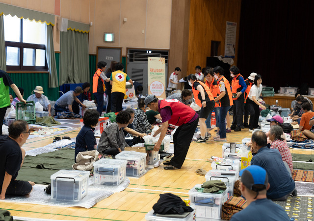 충청 지역의 구세군 사관(목사)과 봉사자가 17일 충남 논산의 원봉초등학교에 대피한 이재민들에게 구호 물품을 나눠주고 있다. 구세군 제공