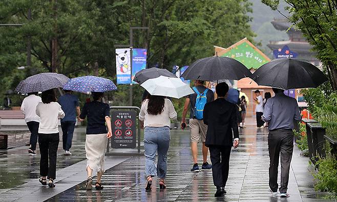 장맛비가 내리고 있는 18일 서울 광화문광장에서 우산을 쓴 시민들이 발걸음을 옮기고 있다. 뉴스1