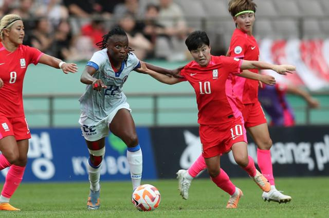 지소연(오른쪽)이 8일 서울 상암월드컵경기장에서 열린 여자축구 국가대표 평가전 아이티와의 경기에서 상대 수비와 몸싸움을 하고 있다. 뉴시스